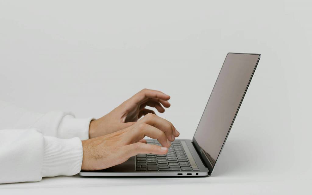 Manos sobre un teclado interactuando con un software de asistente virtual