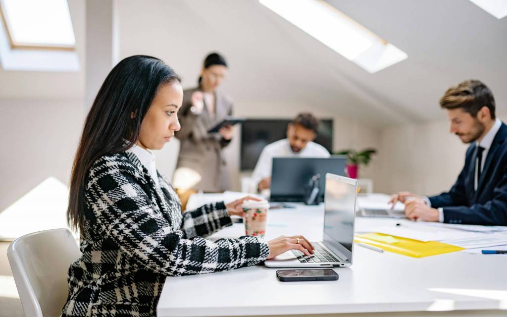 Personas trabajando con computadoras en una oficina gracias a un ecm enterprise content management