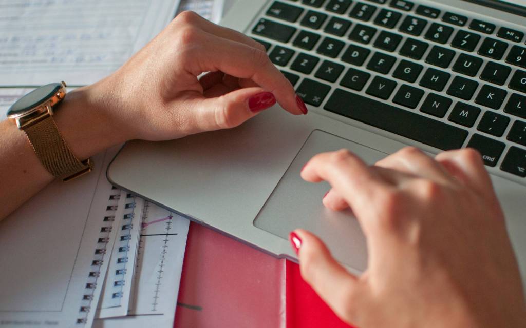 Manos trabajando en una computadora en un proceso fiscal automatizado