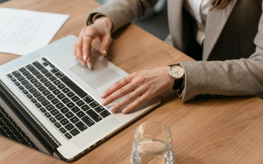 Manos sobre una pc representando como trabajan utilizando IA Generativa en la banca